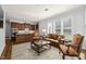 Living room with hardwood floors and large windows near the kitchen area with dark wood cabinets at 40 Park Meadow Ln, Youngsville, NC 27596