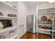 Pantry with open shelving, stainless steel refrigerator, and wood floors at 40 Park Meadow Ln, Youngsville, NC 27596