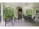 Inviting covered patio with stone fireplace and ample seating overlooking lush greenery at 40 Park Meadow Ln, Youngsville, NC 27596