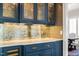 Elegant wet bar showcasing glass-front cabinets, marble countertops, and designer hardware at 40 Park Meadow Ln, Youngsville, NC 27596