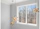 A large window with starburst hanging lights provides ample natural light and view of the surrounding forest at 40 Park Meadow Ln, Youngsville, NC 27596