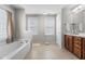 Bright bathroom with soaking tub, tiled floor, and vanity with a mirror, ideal for a relaxing experience at 400 Oxford Park Blvd, Oxford, NC 27565