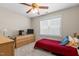 Bright bedroom with large window, single bed, dresser with television on top, and ceiling fan at 400 Oxford Park Blvd, Oxford, NC 27565