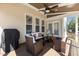 Inviting covered deck with wicker seating, ceiling fan, and a grill, perfect for outdoor relaxation and entertaining at 400 Oxford Park Blvd, Oxford, NC 27565