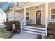 Welcoming front porch with classic columns, a cozy seating area, and manicured landscaping at 400 Oxford Park Blvd, Oxford, NC 27565