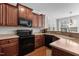 Kitchen featuring dark cabinets, stainless steel appliances, light countertops, and natural lighting at 400 Oxford Park Blvd, Oxford, NC 27565