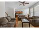 Open-concept living room featuring hardwood floors, a ceiling fan, a tile-topped coffee table, and an area rug at 400 Oxford Park Blvd, Oxford, NC 27565