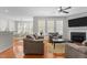 Comfortable living room featuring a fireplace, ceiling fan, hardwood floors, and natural light from the many windows at 400 Oxford Park Blvd, Oxford, NC 27565