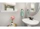 Charming half bath featuring a pedestal sink, round mirror, and decorative accents at 420 Retreat Ln, Wake Forest, NC 27587
