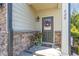Inviting front porch featuring decorative wreath, stone accents, and a charming 'wipe your feet' doormat for a warm welcome at 420 Retreat Ln, Wake Forest, NC 27587