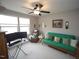 Comfortable living area featuring a green futon, ceiling fan, and natural light from two windows at 420 Retreat Ln, Wake Forest, NC 27587