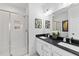 Modern bathroom featuring a double vanity with dark countertops and a glass-enclosed shower at 4810 Gossamer Ln # 105, Raleigh, NC 27616