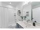 Well-lit bathroom featuring a shower with white tiling, a sink, toilet, and a large mirror at 4810 Gossamer Ln # 105, Raleigh, NC 27616