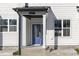 Inviting townhome exterior featuring a blue door, white trim, and a covered porch at 4810 Gossamer Ln # 105, Raleigh, NC 27616