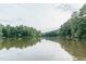 Tranquil lake with sky reflections, surrounded by lush trees, inviting a peaceful escape at 4810 Gossamer Ln # 105, Raleigh, NC 27616