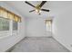 Neutral bedroom featuring a ceiling fan, multiple windows, and neutral carpet, creating a cozy and inviting atmosphere at 4905 Will-O-Dean Rd, Raleigh, NC 27616