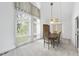Sun-filled dining room featuring cathedral ceilings, large windows, modern chandelier and a ceiling fan at 4905 Will-O-Dean Rd, Raleigh, NC 27616
