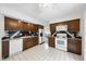 Traditional kitchen featuring wood cabinets, white appliances, tile floors, and an adjacent dining area at 4905 Will-O-Dean Rd, Raleigh, NC 27616