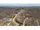 Sweeping aerial shot of wooded area with winding road and homesites in a peaceful community at 5507 Eagles Nest Trl, Snow Camp, NC 27349