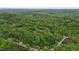 Areal view of a house nestled in a lush green forest with winding roads at 5507 Eagles Nest Trl, Snow Camp, NC 27349