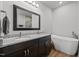 Modern bathroom featuring a double vanity with granite countertops, a soaking tub, and stylish fixtures at 5507 Eagles Nest Trl, Snow Camp, NC 27349