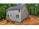 A gray two-story home boasts newly installed siding and a wooden staircase leading to a side door at 5507 Eagles Nest Trl, Snow Camp, NC 27349