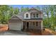 Charming two-story home featuring a covered front porch, two car garage and classic gray siding at 5507 Eagles Nest Trl, Snow Camp, NC 27349