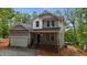 Charming two-story home featuring a covered front porch, two car garage and classic gray siding at 5507 Eagles Nest Trl, Snow Camp, NC 27349