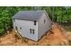 A gray two-story home boasts newly installed siding and a wooden staircase leading to a side door at 5507 Eagles Nest Trl, Snow Camp, NC 27349
