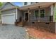 Covered front porch featuring sturdy wooden support columns and brick base with black metal railing at 5507 Eagles Nest Trl, Snow Camp, NC 27349
