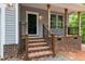 Covered front porch featuring sturdy wooden support columns and brick base with black metal railing at 5507 Eagles Nest Trl, Snow Camp, NC 27349