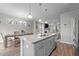 Open concept kitchen with gray cabinetry and island extending into dining and living spaces at 5507 Eagles Nest Trl, Snow Camp, NC 27349