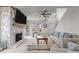 Well-lit living room showcasing a brick fireplace, large TV, and comfortable seating arrangements at 5507 Eagles Nest Trl, Snow Camp, NC 27349