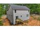 Back exterior view of a gray two-story home with a wooden deck and sliding glass door at 5507 Eagles Nest Trl, Snow Camp, NC 27349