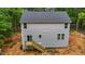 Back exterior view of a gray two-story home with a wooden deck and sliding glass door at 5507 Eagles Nest Trl, Snow Camp, NC 27349