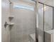 Modern bathroom shower featuring gray tiling, a built-in bench, and a glass door at 553 Winding Creek Dr, Lillington, NC 27546