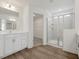 Well lit bathroom with white cabinets, wood floors, and a glass enclosed shower at 553 Winding Creek Dr, Lillington, NC 27546