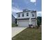 Beautiful two-story home with white siding, a two-car garage, and a lovely landscaped yard at 553 Winding Creek Dr, Lillington, NC 27546