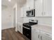 Modern kitchen with stainless steel appliances, white cabinets, and quartz countertops at 553 Winding Creek Dr, Lillington, NC 27546