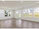 Bright living room with hardwood floors and large windows offering scenic backyard views at 553 Winding Creek Dr, Lillington, NC 27546