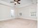 Main bedroom showing tray ceiling, windows for natural light, and a door to the bathroom at 601 Copper Beech Ln, Wake Forest, NC 27587