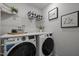 Functional laundry room with a washer, dryer, overhead storage, and modern appliances at 63 Capewood Ct, Garner, NC 27529