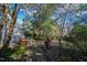 Spacious backyard featuring a brick pathway, patio with outdoor seating, privacy fencing and mature trees at 632 E Franklin St, Raleigh, NC 27604
