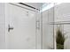 White tiled walk-in shower with a glass door and black accents at 632 E Franklin St, Raleigh, NC 27604