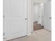 Hallway with hardwood floors visible, white trim, carpet in bedroom at 71 Hawksmoore Ln, Lillington, NC 27546