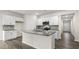 Bright kitchen with white cabinetry, granite countertops, stainless appliances, and a central island with a sink at 71 Hawksmoore Ln, Lillington, NC 27546
