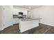 Well-lit kitchen with white cabinets, gray backsplash, stainless steel appliances, and large island with sink at 71 Hawksmoore Ln, Lillington, NC 27546
