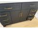 Close up of a black vanity cabinet with sleek gold hardware and drawers in a bathroom at 82 Cool Creek Dr, Willow Springs, NC 27592