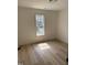 Bright bedroom features wood flooring and a window offering ample natural light and neighborhood views at 82 Cool Creek Dr, Willow Springs, NC 27592