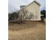 A side angle view of the house showing the vinyl siding, brick foundation, and the outdoor surroundings at 82 Cool Creek Dr, Willow Springs, NC 27592